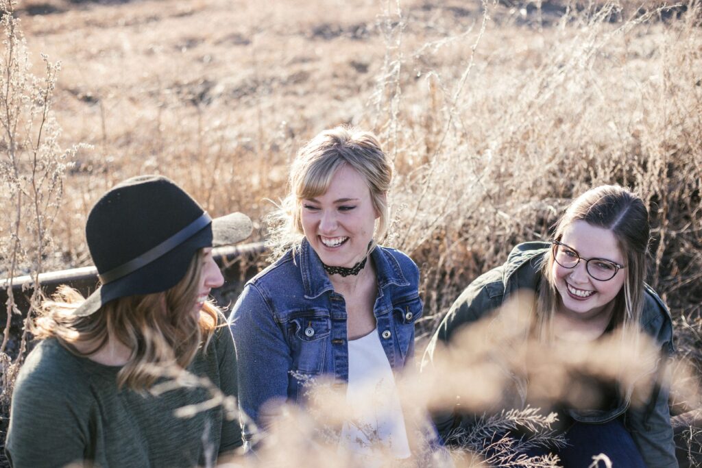 A group of female friends laughing in a field together